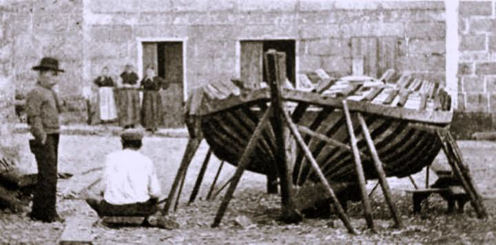 Construción dunha dorna de tope no Borrón. San Tomé.
De costas e sentado, o mestre calafate Avelino Suárez « O Freixán».